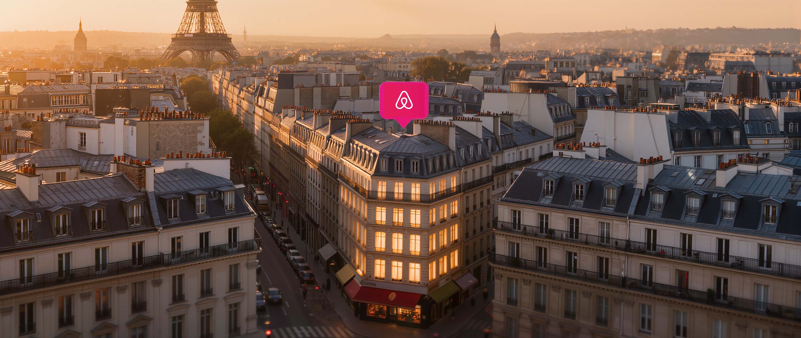 Aerial view of Parisian rooftops at sunset with an Airbnb pin on a Haussmann building